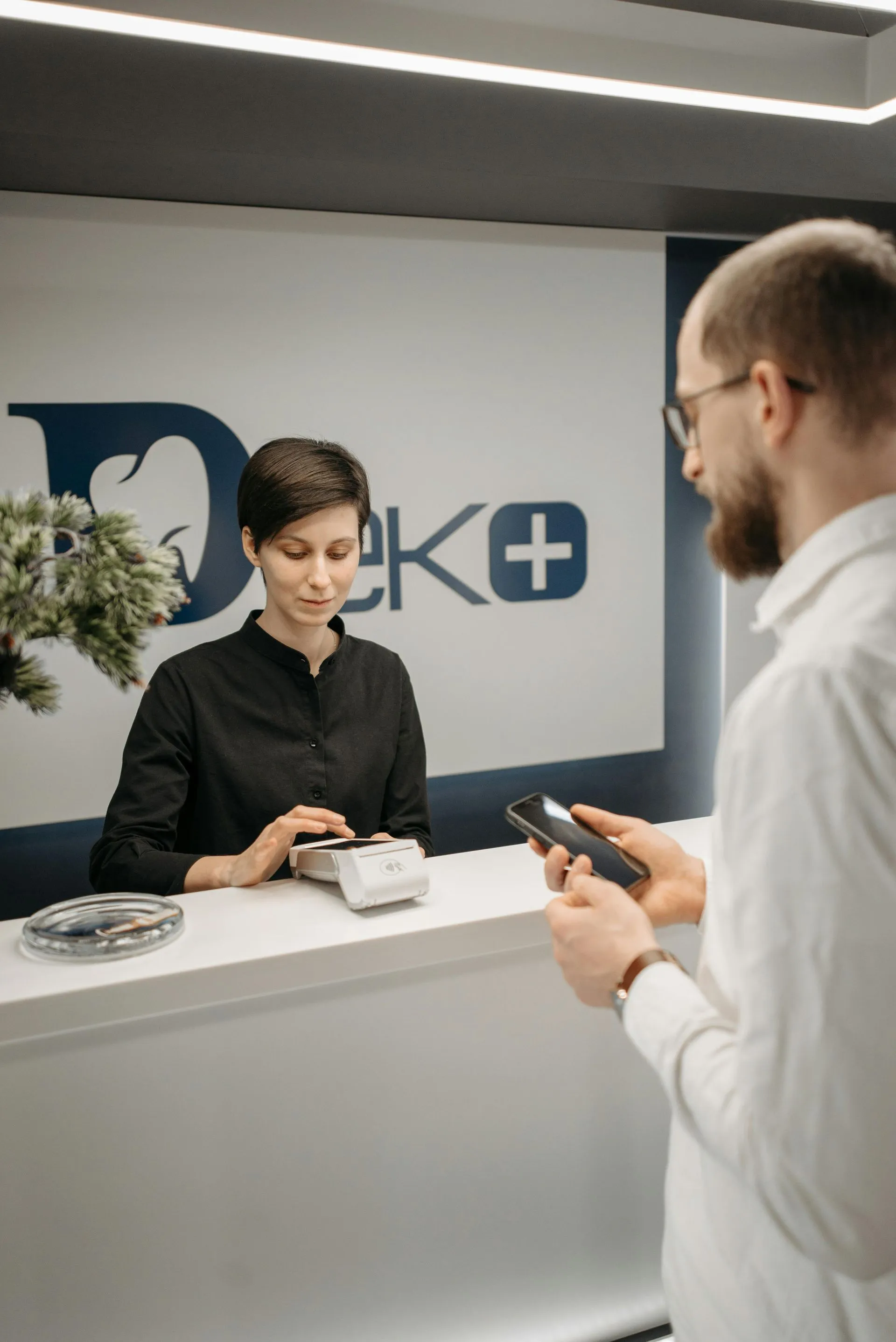 Receptionist assisting a customer in a modern office lobby
