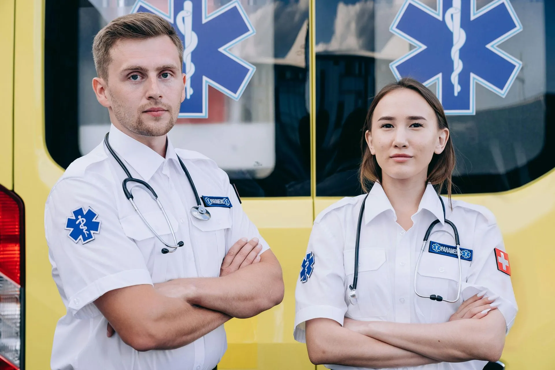 Two paramedics standing in front of an ambulance