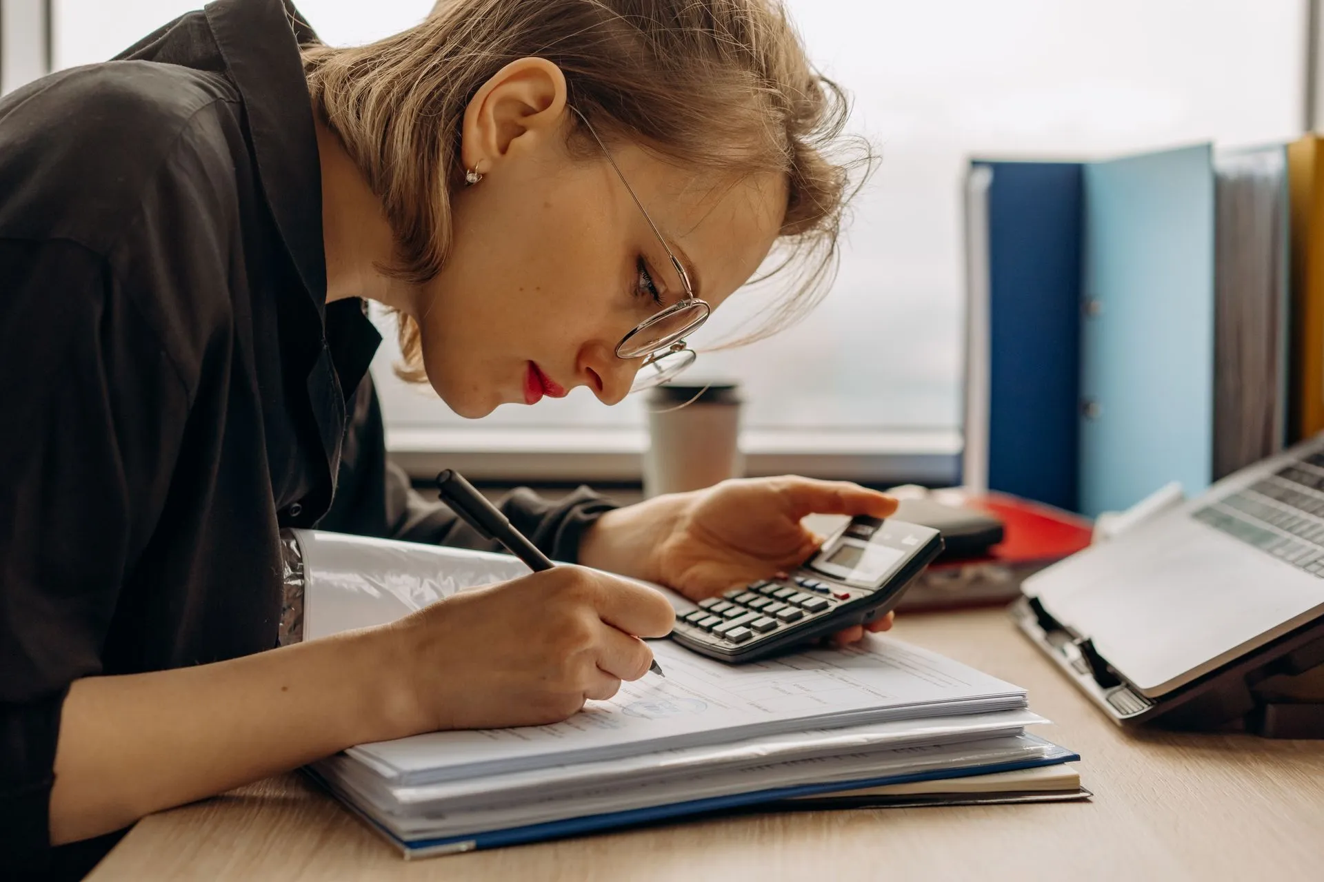 Business owner using a calculator and notebook