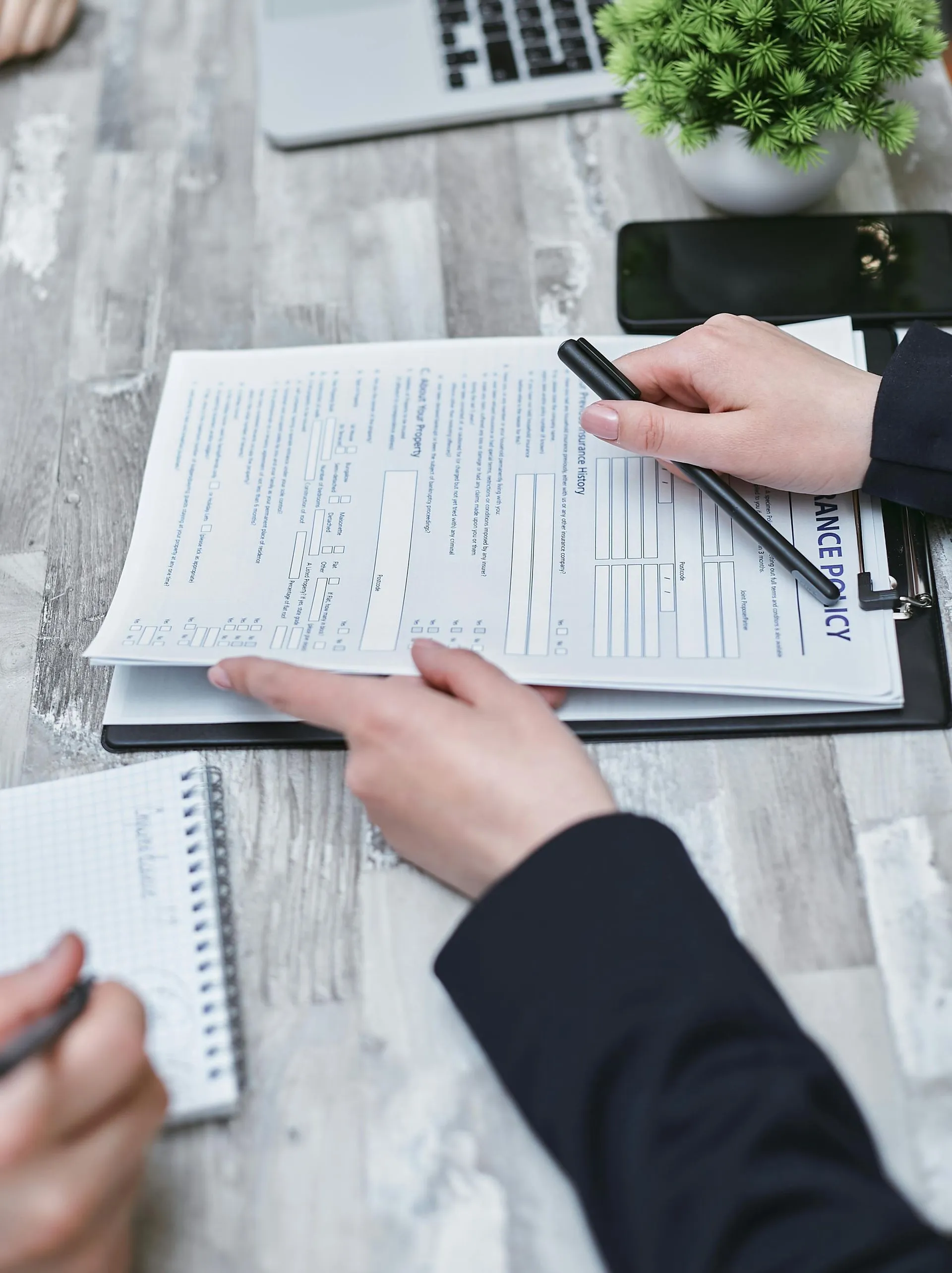 Hands reviewing a claim form and billing notes