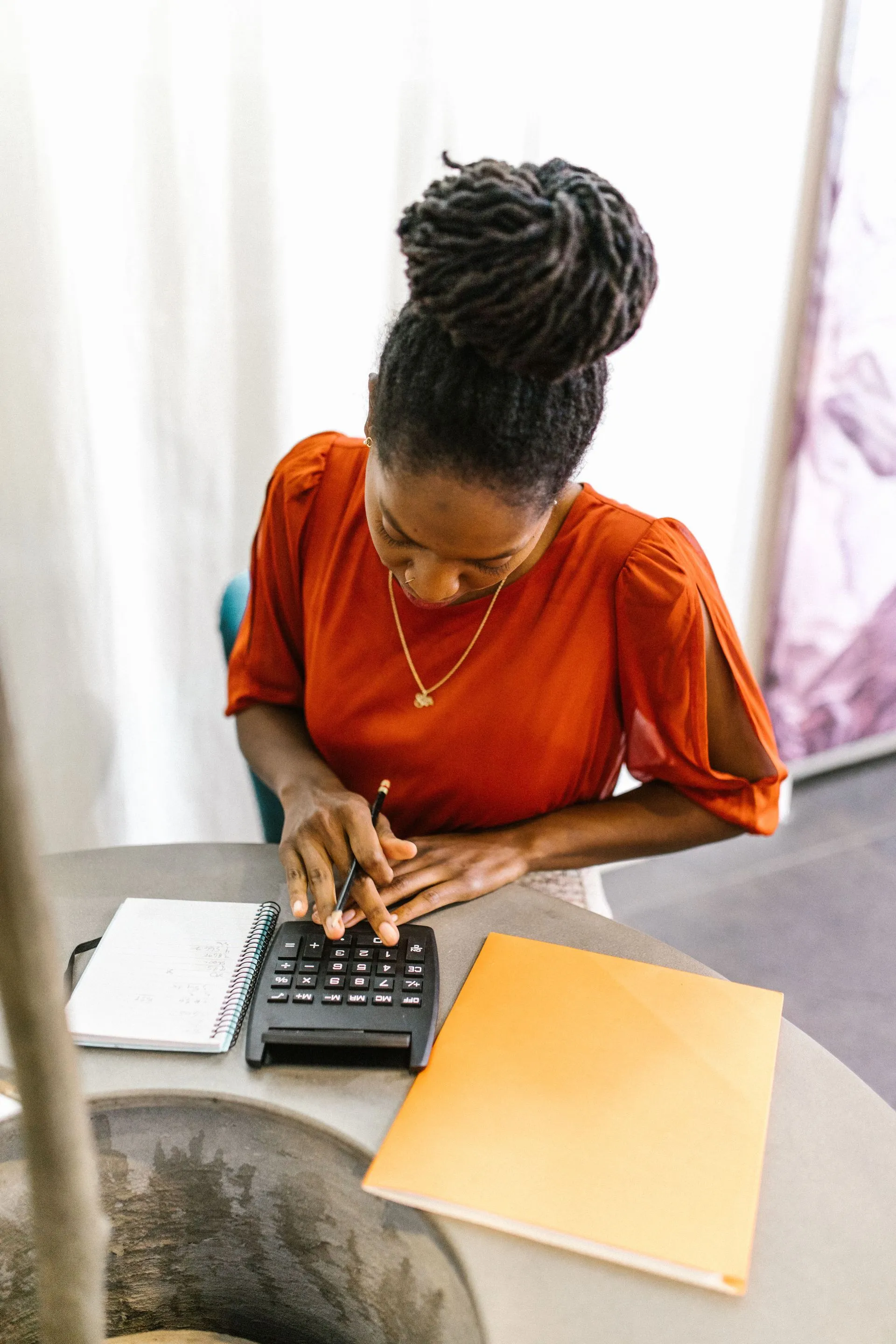 Small business owner reviewing figures with a calculator