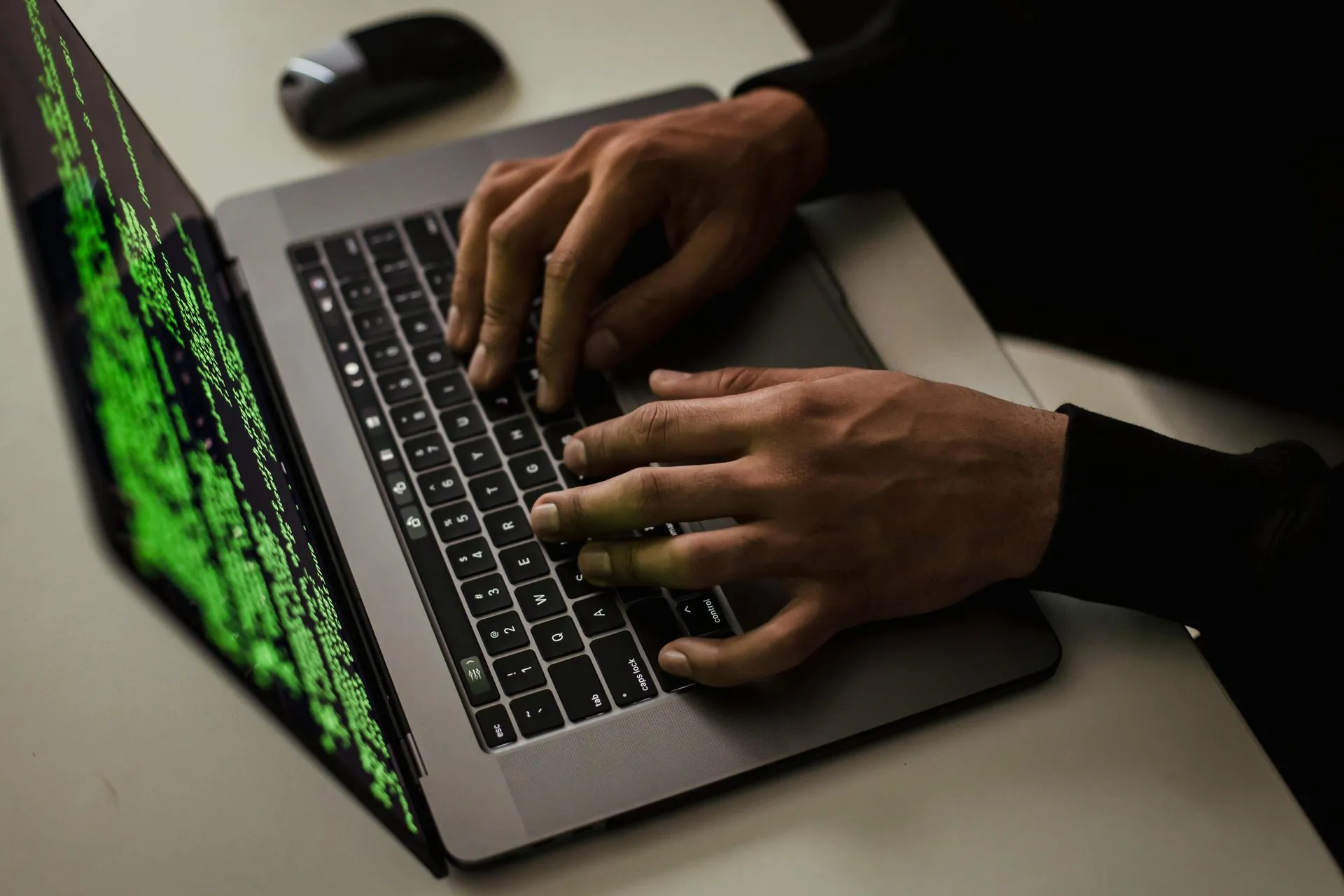 Hands typing on a laptop used for coding work