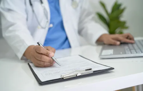 Clinician reviewing a patient form on a clipboard